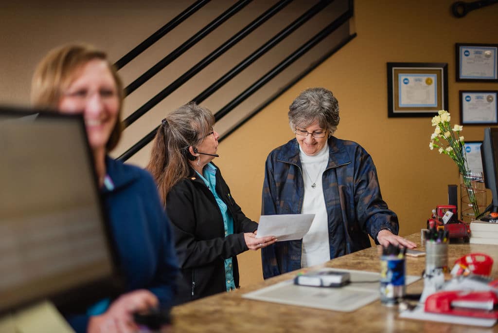 Photo of Staff Interacting with Female Customer in Lobby at McCormick Automotive Center in Fort Collins, Colorado