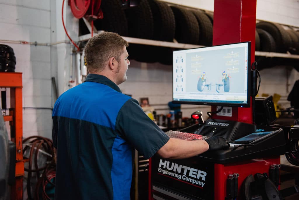 Photo of Mechanic Performing a Tire Alignment and Looking at Software Screen at McCormick Automotive Center in Fort Collins, Colorado